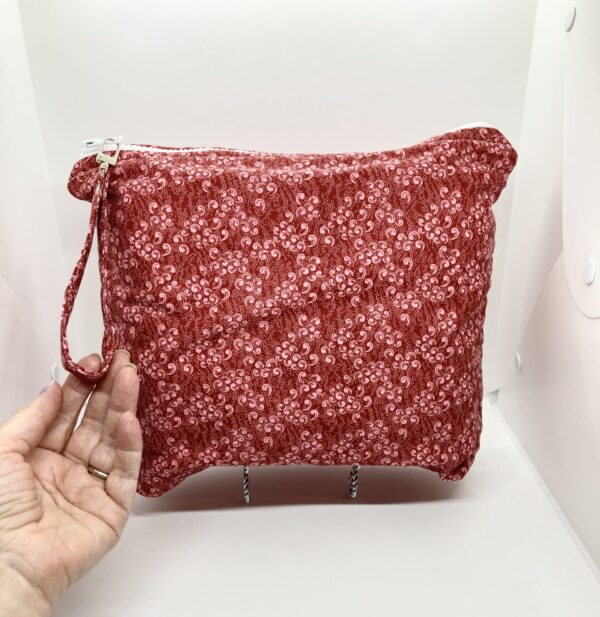 Large project bag with cranberry calico fabric and zipper closure at the top with an accessbile handle attached to the zipper.
