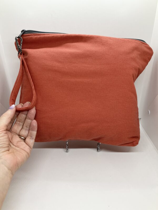 eleven by thirteen inch project bag handcrafted with burnt orange upcycled fabric. Zipper is included with an accessbile handle which makes it easier to open and closer. The lining is a light color which helps to see the interior more easily.