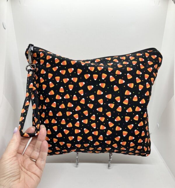 eleven by thirteen inch project bag handcrafted with candy corn upcycled fabric. Zipper is included with an accessbile handle which makes it easier to open and closer. The lining is a light color which helps to see the interior more easily.