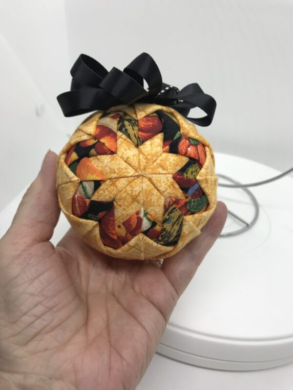 Front View Golden 3" Round Ornament with Basic Star Pattern with fruit printed fabrics, black bow and hangerjpeg