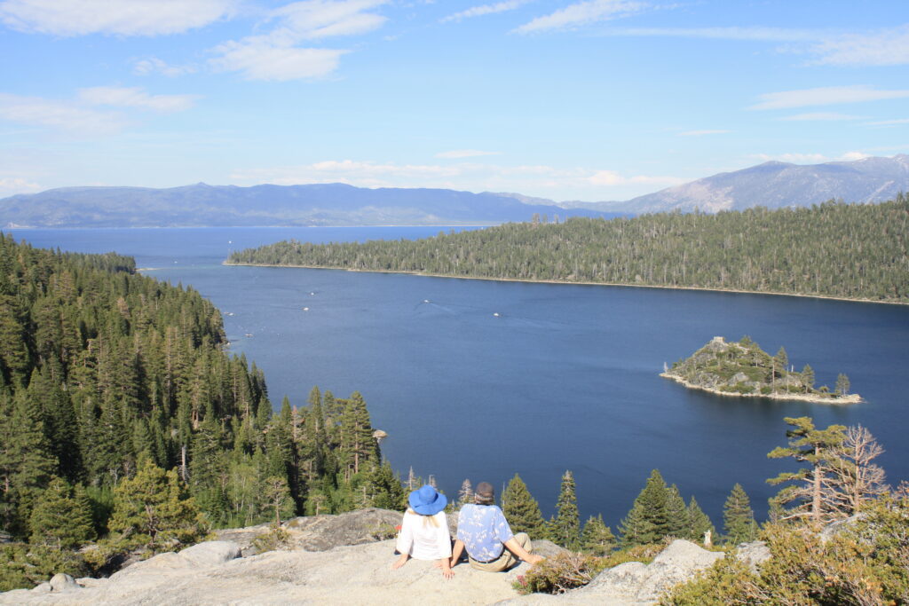 My husband and I are sitting on large rock, looking out on Emerald Bay, off of Lake Tahoe.