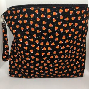 11" X 13" bag with Candy Corn print on a black background with a wristlet attached to the zipper.