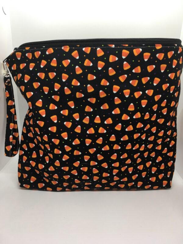 11" X 13" bag with Candy Corn print on a black background with a wristlet attached to the zipper.
