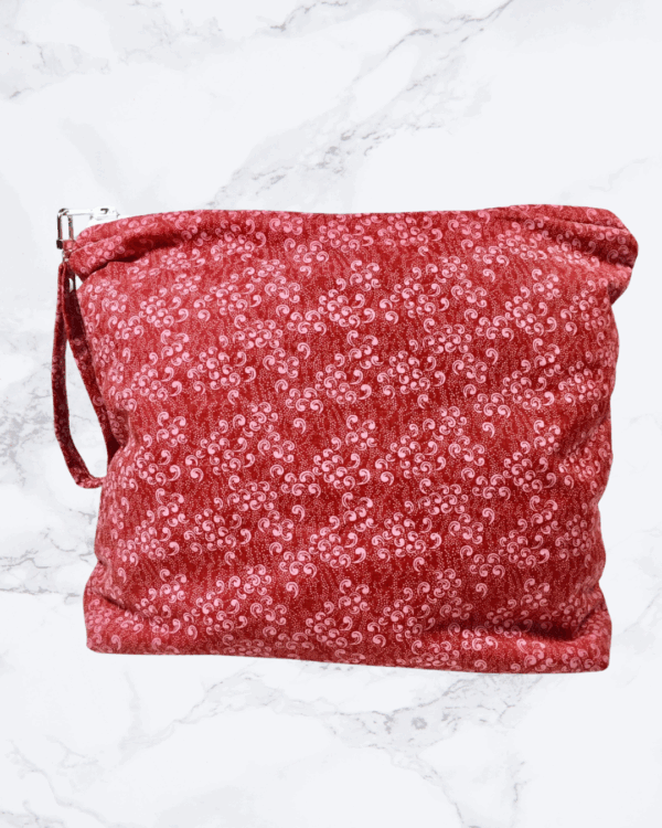 Large project bag with cranberry calico fabric and zipper closure at the top with an accessbile handle attached to the zipper.