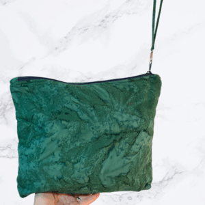 Eleven by thirteen inch project bag handcrafted with a dark green batik fabric. Has a zipper closure with an accessible handle attached to the zipper.