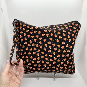 eleven by thirteen inch project bag handcrafted with candy corn upcycled fabric. Zipper is included with an accessbile handle which makes it easier to open and closer. The lining is a light color which helps to see the interior more easily.