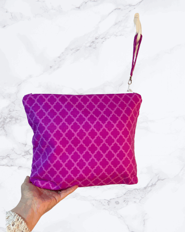 Eleven by thirteen inch project bag handcrafted with a fuschia diamond pattern. Has a zipper closure with an accessible handle attached to the zipper.